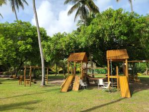a playground in a park with wooden play equipment at Eco Resort Praia dos Carneiros - Flat Novo - Ao Lado da Igrejinha in Praia dos Carneiros