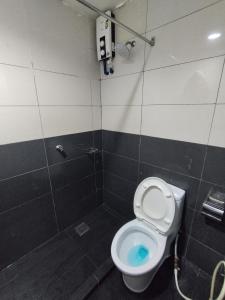 a bathroom with a toilet with blue water in it at Marine Bay Hotel in Sandakan