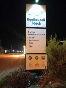 a sign on the side of a road at night at Agathoupoli beach 