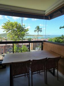 tavolo e sedie in una stanza con una grande finestra di Eco Resort Praia dos Carneiros - Flat Novo - Ao Lado da Igrejinha a Praia dos Carneiros