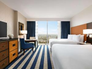 a hotel room with two beds and a television at Fairmont Austin in Austin