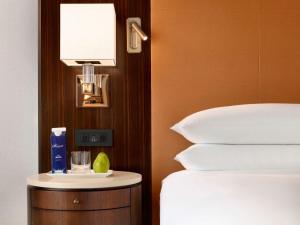 a hotel room with a bed and a night stand with a lamp at Fairmont Austin in Austin