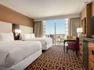 Habitación de hotel con 2 camas y ventana grande. en Fairmont Austin, en Austin