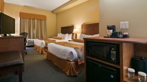 Best Western Plus Service Inn & Suites في ليثبريدج: غرفة فندقية بسريرين وتلفزيون بشاشة مسطحة