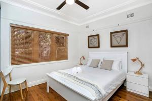 Habitación blanca con cama y ventana en HUNT1 - Great Family Unit, Spacious Green Garden en Sídney