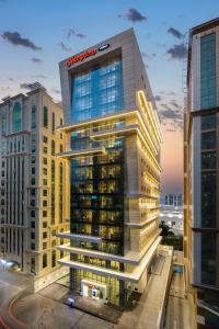 a tall building with a santander sign on it at Hampton By Hilton Doha Old Town in Doha