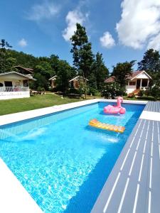 a swimming pool with a pool toy in the water at Baan Suan Rojjana in Muak Lek District