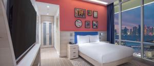 Hampton By Hilton Doha Old Town في الدوحة: غرفة نوم بسرير ابيض ونافذة كبيرة