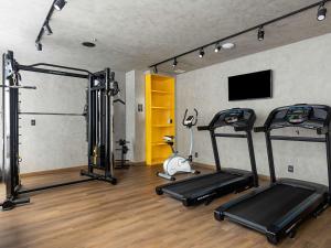 a gym with two tread machines and a tv at ibis Styles Maceió Pajuçara in Maceió