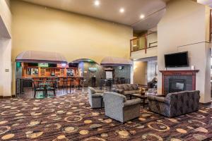 a lobby with chairs and a fireplace and a bar at Quality Inn & Suites Hannibal in Hannibal