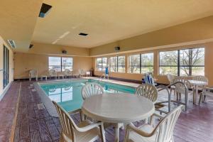 a pool with tables and chairs next to a swimming pool at Best Western Seminole Inn and Suites in Seminole