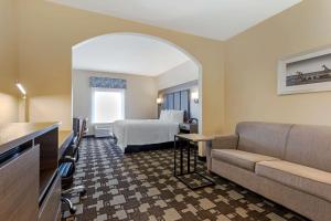 a hotel room with a bed and a couch at Best Western Seminole Inn and Suites in Seminole