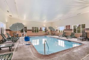 a pool in a hotel with chairs and tables at Sleep Inn & Suites Ronks in Ronks