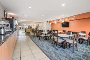 a restaurant with tables and chairs and a bar at Sleep Inn & Suites Ronks in Ronks