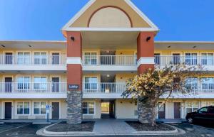 an apartment building with a car parked in a parking lot at Extended Stay America Select Suites - Roanoke - Airport in Roanoke