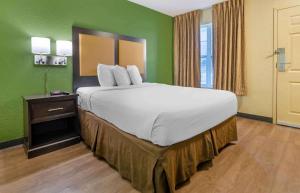ein großes Bett in einem Zimmer mit grünen Wänden in der Unterkunft Extended Stay America Select Suites - Roanoke - Airport in Roanoke