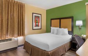 a large bed in a hotel room with green walls at Extended Stay America Suites - Merrillville - US Rte 30 in Merrillville