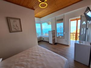 - une chambre avec un lit et une vue sur l'océan dans l'établissement Flower Hill, à Vlorë