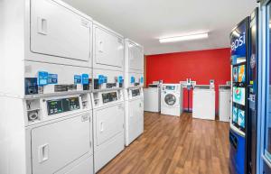 a laundry room with white machines and a red wall at Extended Stay America Suites - Chesapeake - Crossways Blvd in Chesapeake