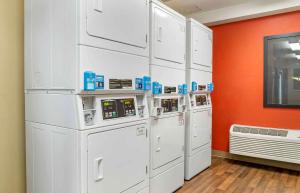 a group of white appliances in a room with an orange wall at Extended Stay America Select Suites - Detroit - Farmington Hills in Farmington Hills
