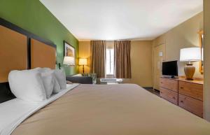 Una habitación de hotel con una cama grande y un televisor. en Extended Stay America Suites - Kansas City - Shawnee Mission, en Merriam