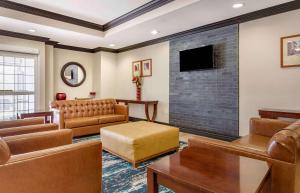 a living room with leather furniture and a flat screen tv at Extended Stay America Suites - Houston - Kingwood in Kingwood
