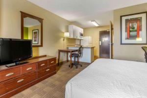 a hotel room with a bed and a flat screen tv at Extended Stay America Suites - Phoenix - Deer Valley in Phoenix