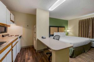 a small hotel room with a bed and a kitchen at Extended Stay America Suites - Dayton - Fairborn in Dayton