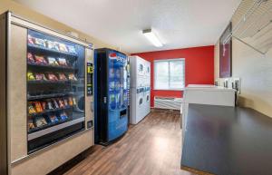 a kitchen with a large refrigerator and red walls at Extended Stay America Suites - Dayton - Fairborn in Dayton