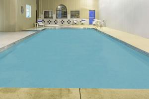 a swimming pool with blue water in a room at Super 8 by Wyndham Gallipolis Pt Pleasant Area in Gallipolis