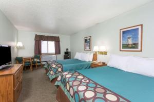 a hotel room with two beds and a flat screen tv at Super 8 by Wyndham Gallipolis Pt Pleasant Area in Gallipolis
