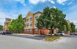 un gran edificio con coches estacionados en un estacionamiento en Extended Stay America Suites - Indianapolis - Airport - W Southern Ave en Indianápolis