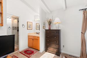 een badkamer met een wastafel, een dressoir en een televisie bij Aspen West End Home in Aspen