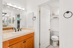 Baño blanco con lavabo y aseo en Aspen West End Home en Aspen