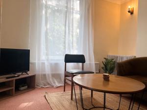 a living room with a table and a television at Canterbury King bed house with Free Parking & Garden in Canterbury
