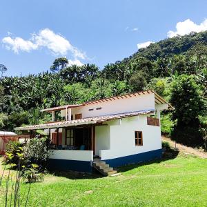 哈爾丁的住宿－Glamping Jardín，一座白色的房子,后面有一座小山