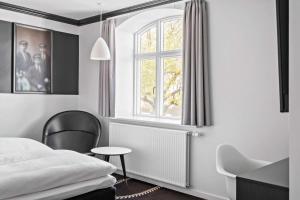 um quarto com uma cama, uma cadeira e uma janela em Best Western Plus Hotel Eyde em Herning