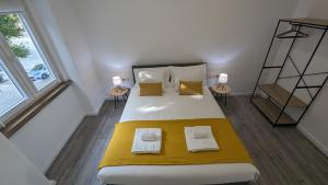 1 dormitorio con 1 cama grande con sábanas y almohadas amarillas en Golligo Apartments, en Sintra