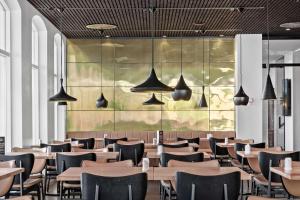 Un restaurante con mesas, sillas y luces. en Best Western Plus Hotel Eyde, en Herning