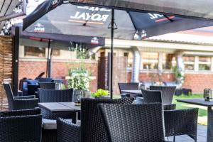 un restaurante al aire libre con mesas, sillas y sombrilla en Scandic Ringsted en Ringsted