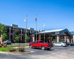 un camión rojo estacionado en un estacionamiento frente a un edificio en Quality Inn & Suites en Peoria