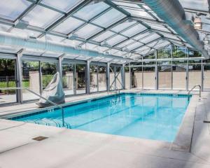 une grande piscine avec un toit en verre dans l'établissement Quality Inn & Suites, à Peoria