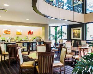 un restaurante con mesas y sillas y un bar en Quality Inn & Suites, en Peoria