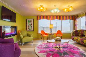 sala de estar con sillas coloridas y mesa en Clarion Inn & Suites, en Evansville