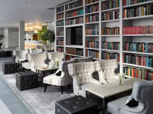 a library with couches and book shelves with books at Radisson Blu Hotel East Midlands Airport in Castle Donington