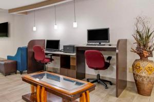 an office with two desks with two monitors and red chairs at Comfort Suites At WestGate Mall in Spartanburg