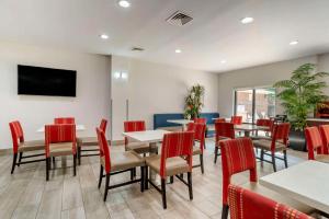 a dining room with tables and chairs and a flat screen tv at Comfort Suites At WestGate Mall in Spartanburg