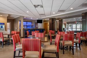 a dining room with red chairs and a table at Comfort Inn in Connellsville