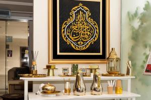 Palm Boutique Al Zahra بالم بوتيك الزهراء في جدة: طاولة مع مزهريات وصورة على الحائط +33 صورة