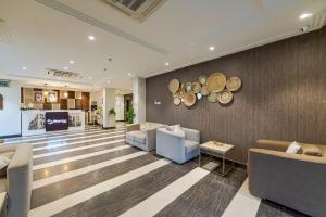 Palm Boutique Al Zahra بالم بوتيك الزهراء في جدة: لوبي فيه كنب وكراسي وجدار فيه قبعات